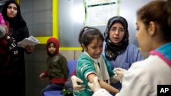 FILE - A Syrian girl weeps after receiving the measles vaccine from UNICEF nurses at the U.N. refugee agency's registration center in Zahleh, in Lebanon's Bekaa Valley.