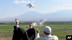 Pope Francis, right, and Catholicos Karekin II release white doves after a ceremony at the Khor Virap's monastery, Armenia, June 26, 2016. (L'Osservatore Romano/Pool photo via AP)