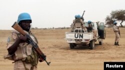 FILE - UN peacekeepers stand guard in the northern town of Kouroume, Mali.