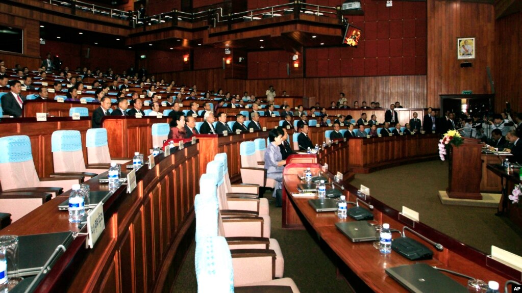 FILE - Prime Minister Hun Sen, front row center, and lawmakers from his ruling Cambodian People's Party sit near empty seats held by opposition lawmakers, inside the session hall of the National Assembly, in Phnom Penh, Cambodia, Tuesday, Sept. 24, 2013. 