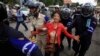 A protester is detained by Cambodian police officers during a rally in support of seven detained activists, in front of the Phnom Penh Municipal Court, in Phnom Penh, Nov. 11, 2014.