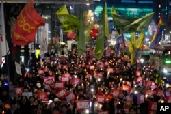 Protesters march to the presidential office after a candlelight vigil against South Korean President Yoon Suk Yeol in Seoul, South Korea, Dec. 5, 2024.