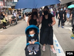 有家長帶同年幼兒子一同戴上口罩參與10月5日”全民蒙面遊行”，反對當局實施”禁蒙面法” (美國之音湯惠芸拍攝)