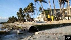A man walks beside a drainage pipe that discharges its untreated sewage into the waters along the beachfront of the country's most famous beach resort island of Boracay, in central Aklan province, Philippines, as the government implements it's temporary c