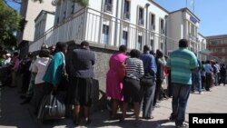 Residents queue to withdraw cash at a local bank in Harare, Zimbabwe, May 5, 2016.