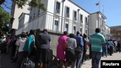 Residents queue to withdraw cash at a local bank in Harare, Zimbabwe, May 5, 2016.