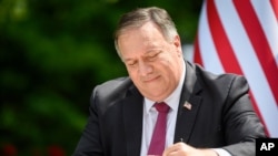 FILE - US Secretary of State Mike Pompeo signs an agreement on fifth-generation internet technology with Slovenia's Foreign Minister Anze Logar in Bled, Slovenia, Aug. 13, 2020.