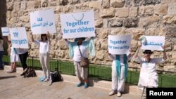 Sejumlah aktivis perempuan Israel, baik etnis Yahudi maupun Arab, melakukan aksi unjuk rasa menyerukan perdamaian di luar tembok Kota Tua Yerusalem hari Rabu (19/5) (Foto: Reuters).