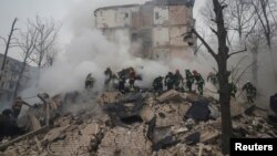 Rescuers work at a site of a residential building heavily damaged during a Russian missile attack, amid Russia's attack on Ukraine, in Kharkiv, Ukraine, Jan. 23, 2024.