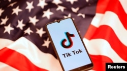 Tik Tok logo is displayed on a smartphone on the U.S. flag in this illustration 