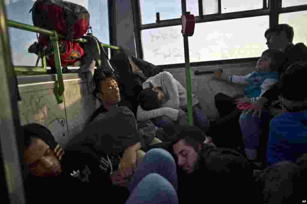 Migrants sleep while waiting in a bus before being taken by Hungarian police to board a train to the Austrian border, in Roszke, southern Hungary. With Hungary cracking down, desperate people fleeing Syria, Afghanistan and elsewhere struggled to make it into the country, hoping to reach Western Europe before it was too late.