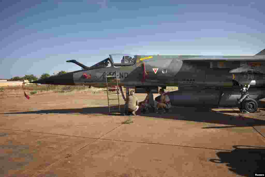 French air force technicians work on a Mirage F-1 fighter jet at the Malian army air base in Bamako, January 14, 2013.