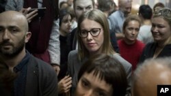 FILE - Russian socialite and opposition member Kseniya Sobchak waits outside a court where Russian theater and film director Kirill Serebrennikov attends a hearing, in Moscow, Oct. 17, 2017.