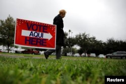 FILE - A woman arrives at a polling station in Lark Community Center as early voting for midterm elections started, in McAllen, Texas, Oct. 22, 2018.