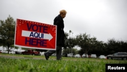 FILE - A woman arrives at a polling station in Lark Community Center as early voting for midterm elections started, in McAllen, Texas, Oct. 22, 2018.