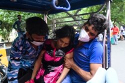 A patient collapses as is rushed on a cycle rickshaw outside a Gurudwara (Sikh Temple) which provides free oxygen to patients under a tent installed along a roadside amid COVID-19 coronavirus pandemic in Ghaziabad on May 4, 2021.