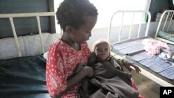 Abdi Nur Ibrahim, 1, who is being treated for severe malnutrition, is cared for by his older sister at a Doctors Without Borders hospital in Dagahaley Camp, outside Dadaab, Kenya, July 15, 2011