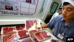 An employee of a store of Costco Japan, the Japanese unit of the American retailer, arranges packs of beef imported from the United States in Makuhari, east of Tokyo, Wednesday, Aug. 9, 2006. U.S. beef went on sale in Japan on Wednesday for the first time