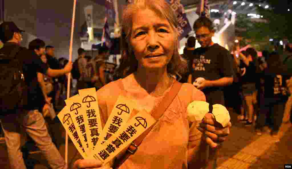 集會人士手持標語及紙摺的黃色小雨傘。(美國之音湯惠芸拍攝)