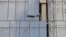 A laborer installs a glass wall on a commercial building under construction in Nanjing, Jiangsu province, China, August 6, 2012.