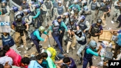 Police personnel baton-charge protesting supporters of Chinmoy Krishna Das Brahmachari, a jailed Hindu monk leader, during a demonstration after court denied his bail in Chittagong, Bangladesh, Nov. 26, 2024. 