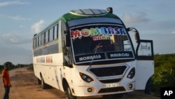 FILE - A man looks at a bus which was ambushed by gunmen in the Nyongoro area of Lamu County, near the Indian Ocean coast of Kenya, Jan. 2, 2020.