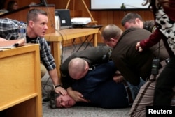 Eaton County sheriffs restrain Randall Margraves after he lunged at Larry Nassar, a former team USA Gymnastics doctor who pleaded guilty in November 2017 to sexual assault charges, during victim statements of his sentencing in the Eaton County Circuit Cou