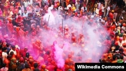 Umat merayakan Holi, festival penuh warna, di dalam Kuil Krishna di Nandgaon, Uttar Pradesh, India, pada 2013.