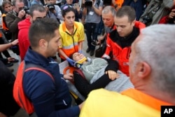 A woman is taken away on a stretcher after civil guards cleared would-be voters at the entrance of a sports center, assigned to be a referendum polling station by the Catalan government in Sant Julia de Ramis, near Girona, Spain, Oct. 1, 2017.