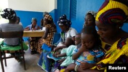 Archives- Les femmes tenant des enfants attendent de recevoir des examens médicaux au centre de santé dans Gbangbégouiné, Côte-d'Ivoire.