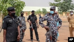 FILE- Security forces guard the Government Girls Junior Secondary School where more than 300 girls were abducted by gunmen, in Jangebe town, Zamfara state, northern Nigeria, Feb. 28, 2021.