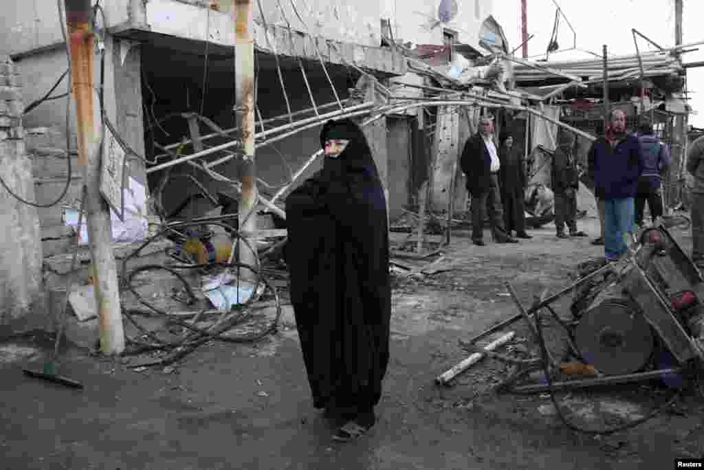 Warga berkumpul di lokasi serangan bom, di distrik Ur timur laut Baghdad, 18 Februari 2014.