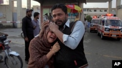 کوئٹہ میں فائرنگ کا نشانہ بننے والے ایک مسیحی شخص کی بیوہ کو اسپتال کے باہر ایک عزیز تسلیاں دے رہا ہے (فائل فوٹو)