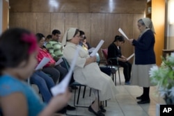 FILE - Migrants participate in a Three Kings Day Mass at the Casa del Migrante shelter run by Catholic nuns in Reynosa, Mexico, Jan. 6, 2016.
