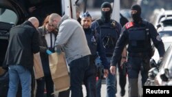 Cảnh sát kiểm tra các túi đựng bằng chứng trong một cuộc tìm kiếm tại Schaerbeek sau vụ đánh bom hôm thứ Ba tại Brussels, Bỉ, ngày 25 tháng 3 năm 2016.