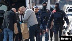 Police look at bags of evidence material during a search in the Brussels borough of Schaerbeek following the March 22 bombings in Brussels, Belgium. (REUTERS/Christian Hartmann)