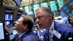 Traders work on the floor of the New York Stock Exchange on Monday, Aug. 8, 2011