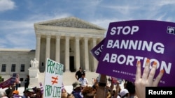 FILE - Abortion rights activists rally outside the U.S. Supreme Court in Washington, May 21, 2019.