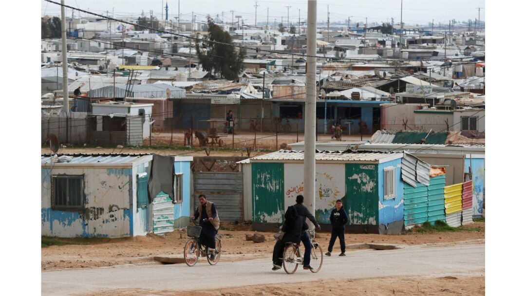 FILE - Syrian refugees ride their bicycles in the Zaatari refugee camp near the border city of Mafraq, Jordan, Feb. 1, 2020.