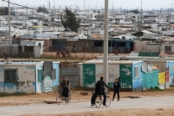 FILE - Syrian refugees ride their bicycles in the Zaatari refugee camp near the border city of Mafraq, Jordan, Feb. 1, 2020.