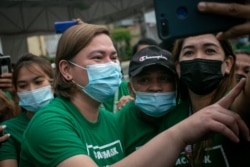 FILE - This photo taken on Nov. 9, 2021 shows Sara Duterte--Carpio (L), mayor and daughter of outgoing Philippines President Rodrigo Duterte, posing for a selfie with city hall employees in Davao city, on the southern island of Mindanao.