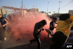 Supporters of Iraqi cleric Muqtada al-Sadr flee the tear gas fired by security forces during clashes after demonstrators broke into Baghdad's fortified "Green Zone," May 20, 2016.