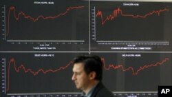 A man walks past an index board at a hall of the Athens Stock Exchange in Athens October 27, 2011. Greek bank stocks jumped more than 13 percent in early morning trade on Thursday after euro zone leaders agreed a new rescue deal for Greece, despite plans 