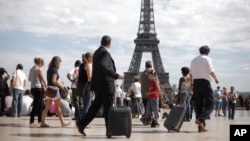 Turis dan pengusaha di alun-alun Trocadero di depan Menara Eiffel.