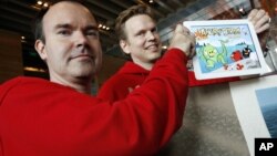 Peter Vesterbacka, Mighty Eagle, Chief Marketing Officer, left, and Henri Holm, Senior Vice President Of Rovio Asia, right, show the latest version of Angry Birds after the opening ceremony of the Shanghai office of Rovio, maker of popular computer game.