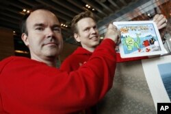 Peter Vesterbacka, Mighty Eagle, Chief Marketing Officer, left, and Henri Holm, Senior Vice President Of Rovio Asia, right, show the latest version of Angry Birds after the opening ceremony of the Shanghai office of Rovio, maker of popular game "Angry Bir