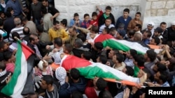 Palestinians carry the bodies of Amer Nassar, 17, and Naji Belbisi, 18, into a mosque during their funeral in the West Bank, April 4, 2013. 