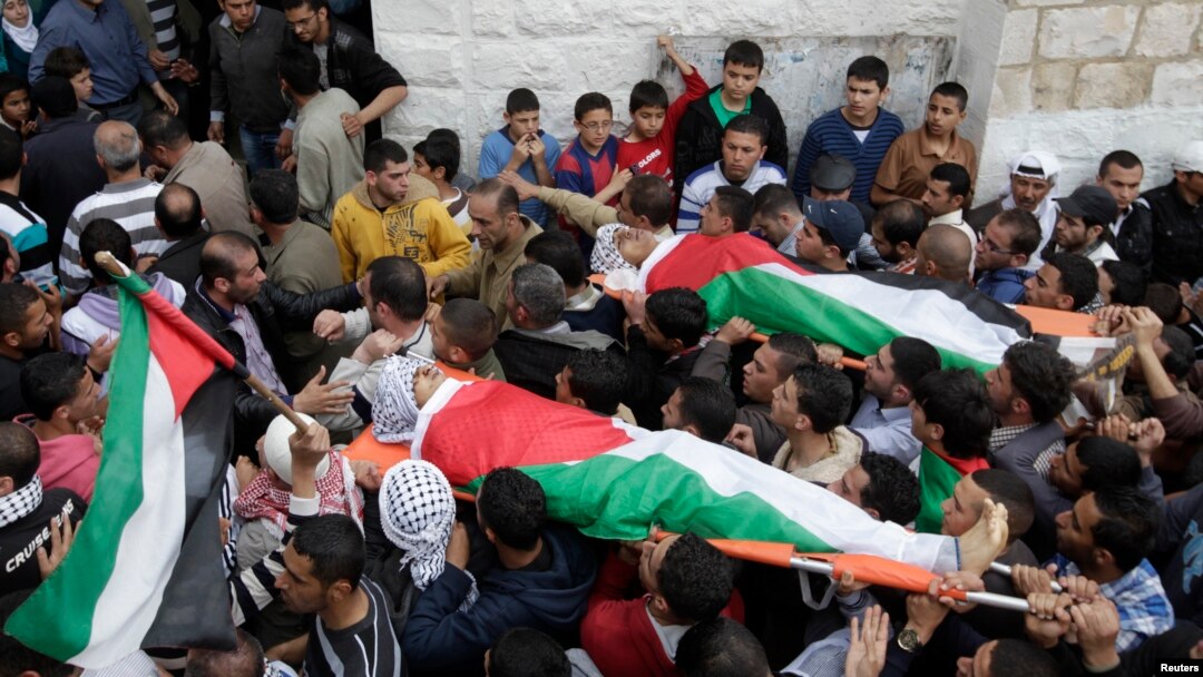 Palestinians carry the bodies of Amer Nassar, 17, and Naji Belbisi, 18, into a mosque during their funeral in the West Bank, April 4, 2013. 