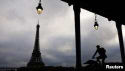 Un hombre monta una bicicleta a lo largo de un carril bici en el puente Pont de Bir-Hakeim, cerca de la Torre Eiffel en París, el 18 de octubre de 2022.