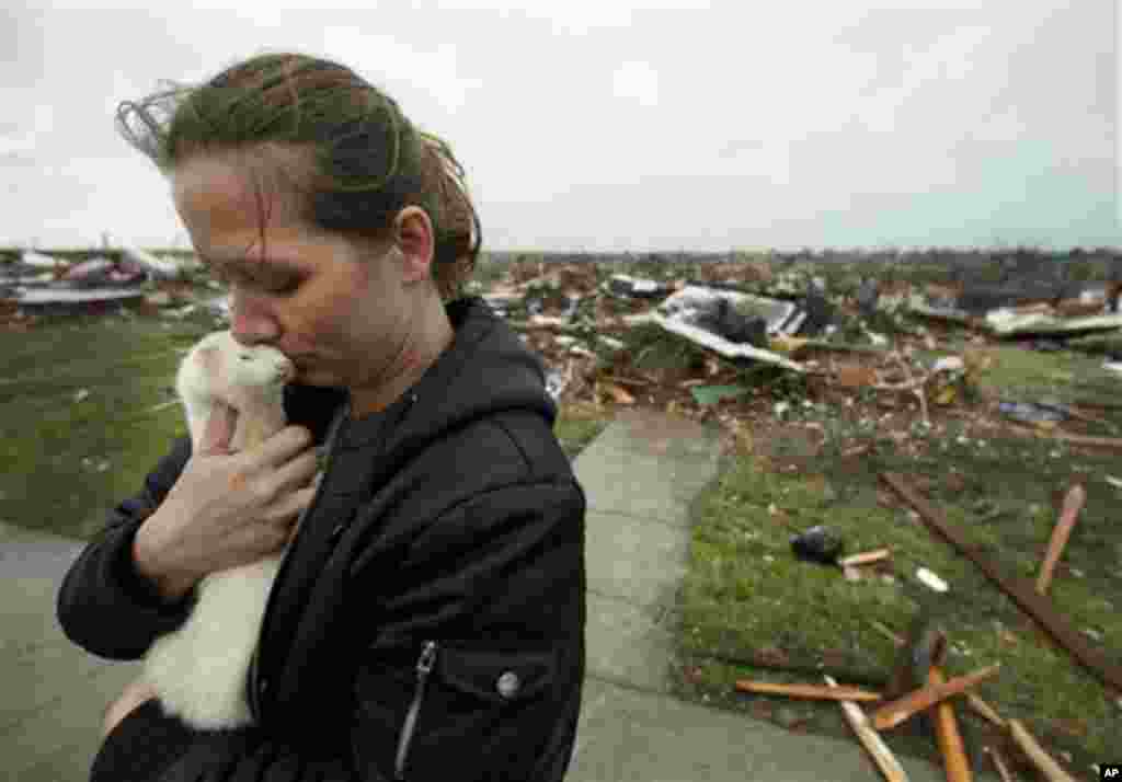 Ashley Stephens holds a ferret she rescued from the home of a missing woman while helping a friend collect belongings Monday, May 23, 2011, in Joplin, Mo. A large tornado moved through much of the city Sunday, damaging a hospital and hundreds of homes and